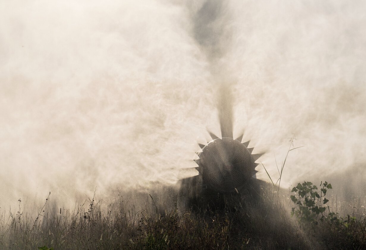 Tractor spraying pesticides on field with sprayer