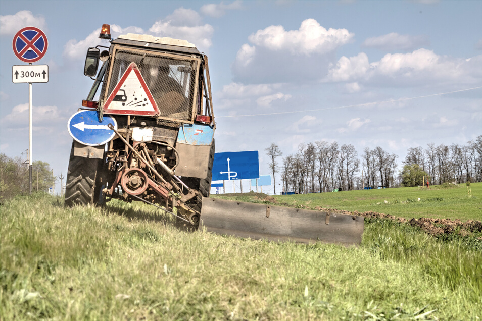 Tractor with a mechanical mower mowing grass